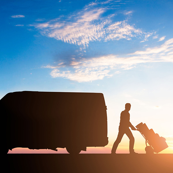 Delivery man with packages on trolley.